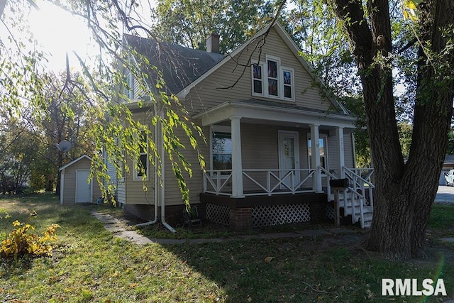 bungalow-style home featuring a shed, a front yard, and a porch