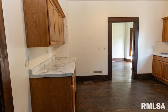 kitchen with dark hardwood / wood-style floors and tasteful backsplash