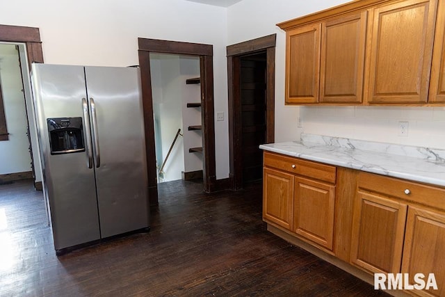 kitchen with stainless steel fridge, light stone countertops, decorative backsplash, and dark hardwood / wood-style floors