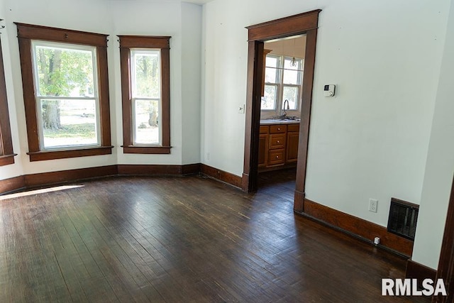 spare room featuring sink and dark hardwood / wood-style floors