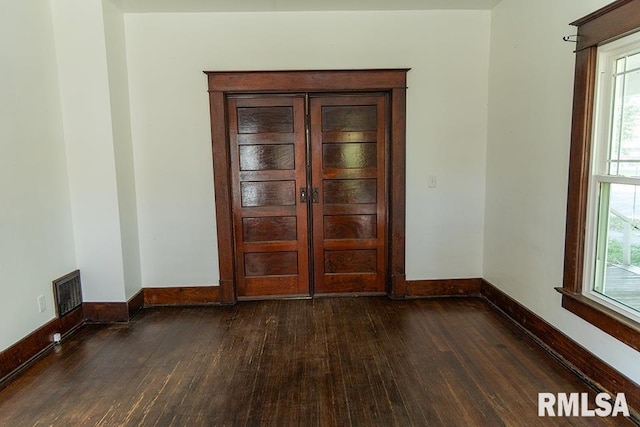 unfurnished room with dark hardwood / wood-style flooring