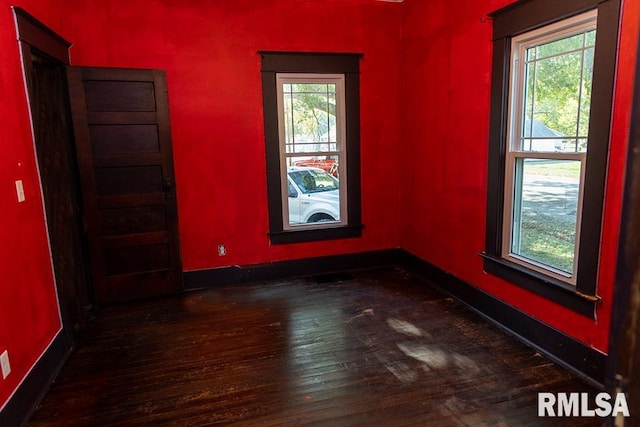 spare room featuring dark hardwood / wood-style floors and plenty of natural light