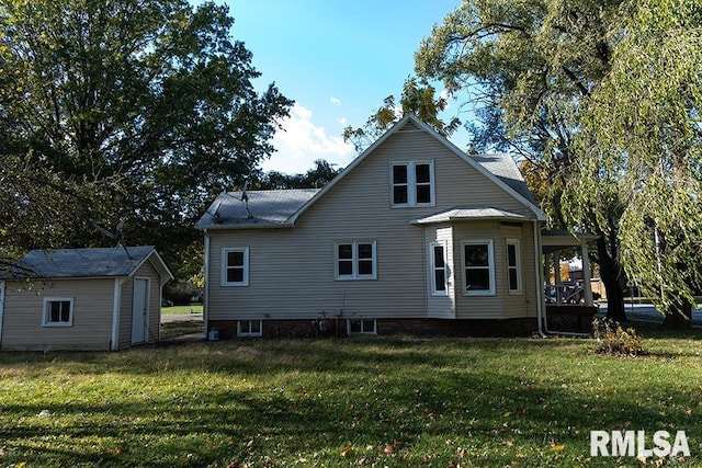 back of property with a storage unit and a lawn