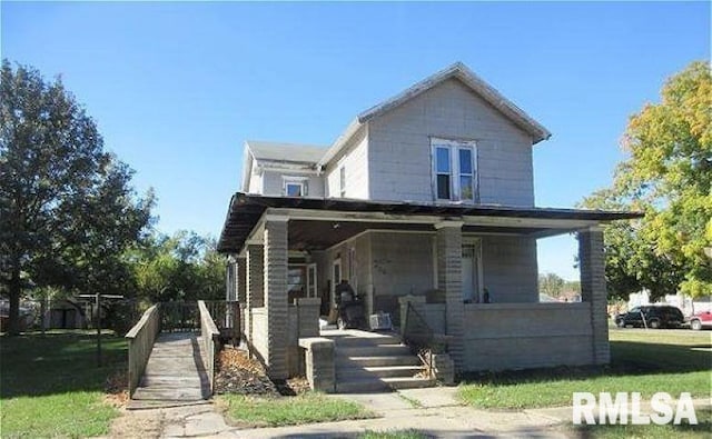 view of front facade with a front lawn and covered porch