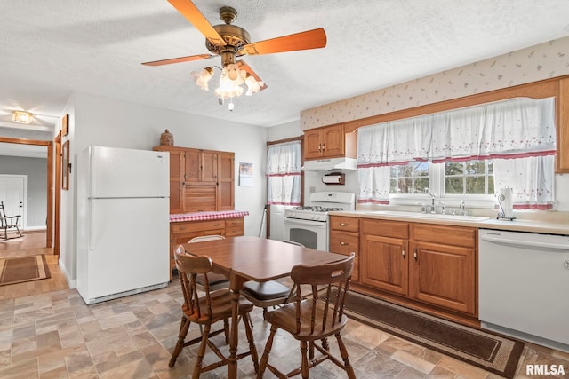 kitchen featuring a textured ceiling, sink, white appliances, and ceiling fan