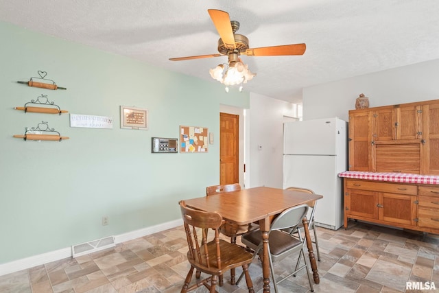 dining room with a textured ceiling and ceiling fan