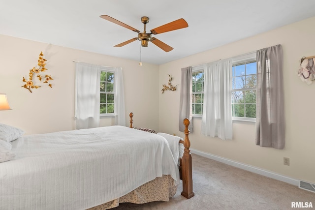 carpeted bedroom featuring multiple windows and ceiling fan