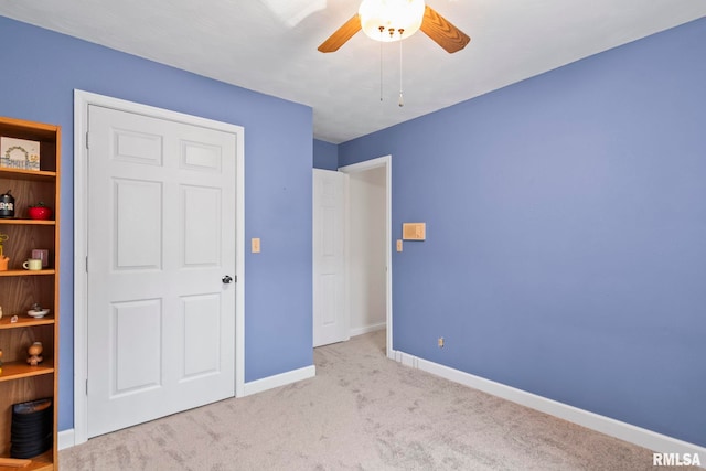 unfurnished bedroom featuring ceiling fan and light carpet