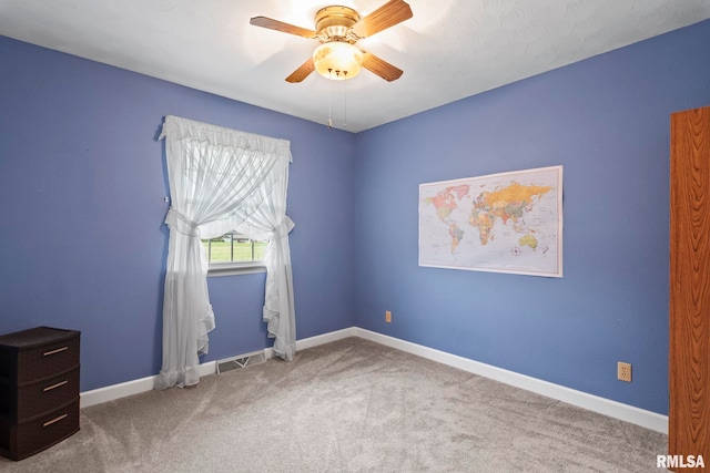 carpeted spare room featuring ceiling fan