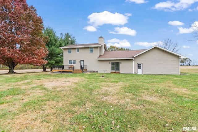 back of house featuring a lawn and a deck