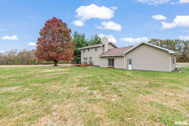 rear view of house featuring a yard and a wooden deck