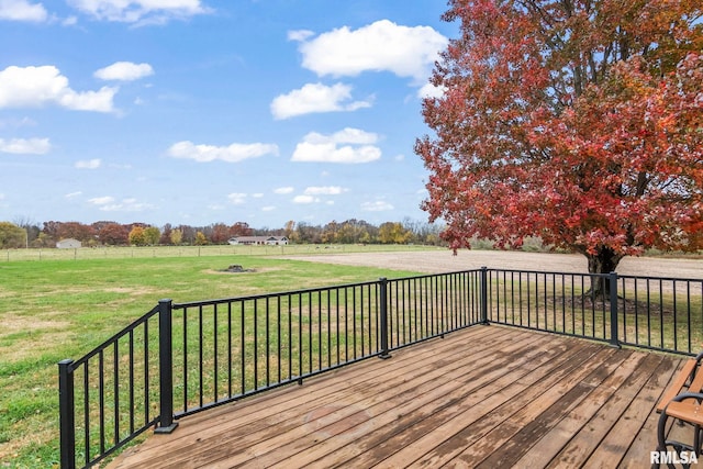 wooden terrace featuring a rural view and a lawn