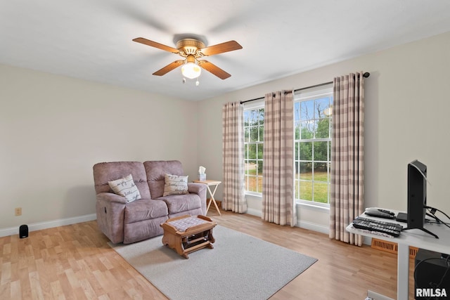 living room featuring a wealth of natural light, ceiling fan, and light hardwood / wood-style flooring