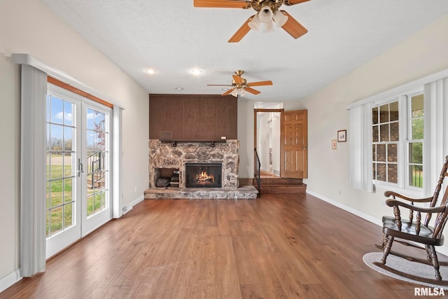 living room featuring a fireplace, a wealth of natural light, and wood-type flooring