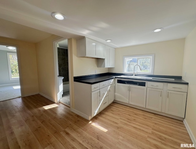 kitchen featuring light hardwood / wood-style flooring, white cabinets, and sink