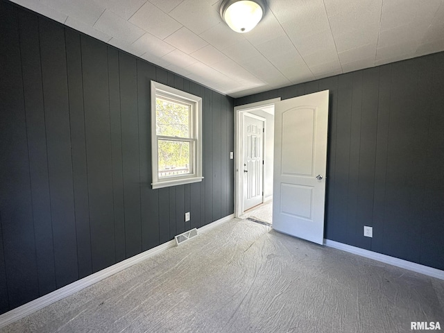 empty room with wooden walls and carpet