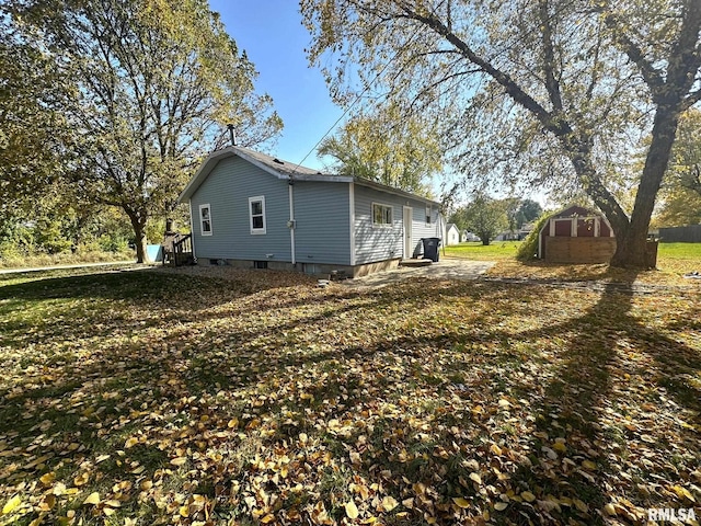 view of home's exterior featuring a yard and a storage unit