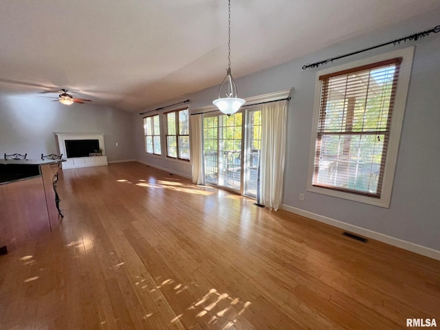 unfurnished living room featuring lofted ceiling, hardwood / wood-style floors, and ceiling fan