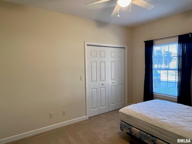 carpeted bedroom with a closet and ceiling fan