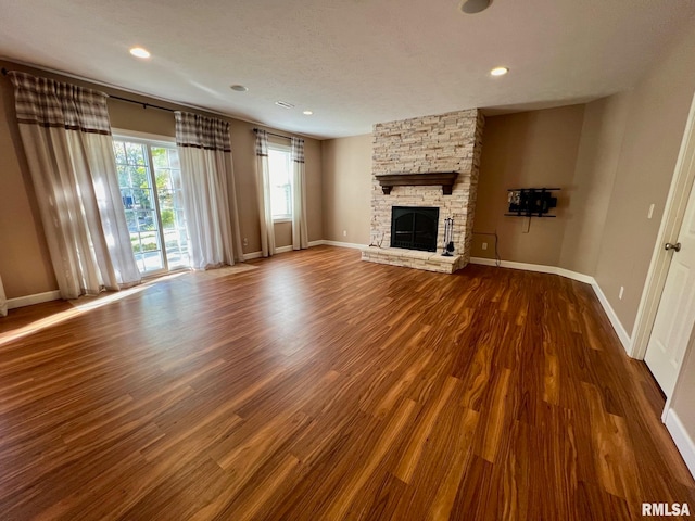 unfurnished living room featuring a textured ceiling, hardwood / wood-style flooring, and a fireplace