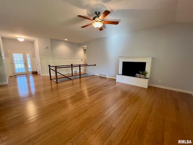 unfurnished living room with light hardwood / wood-style floors, vaulted ceiling, and ceiling fan