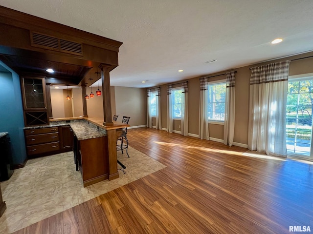 interior space with a textured ceiling, light wood-type flooring, and a wealth of natural light