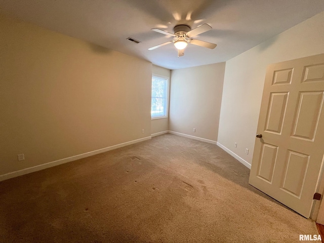 carpeted spare room with ceiling fan