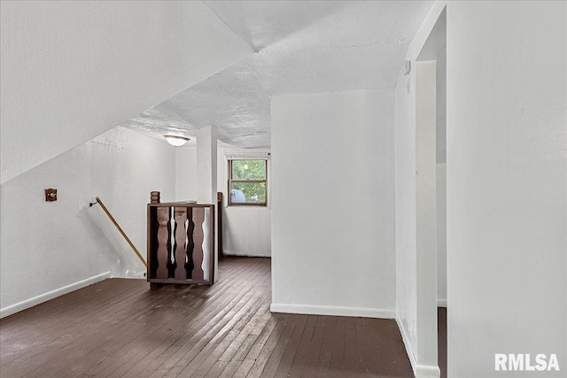 bonus room featuring dark hardwood / wood-style floors and a textured ceiling