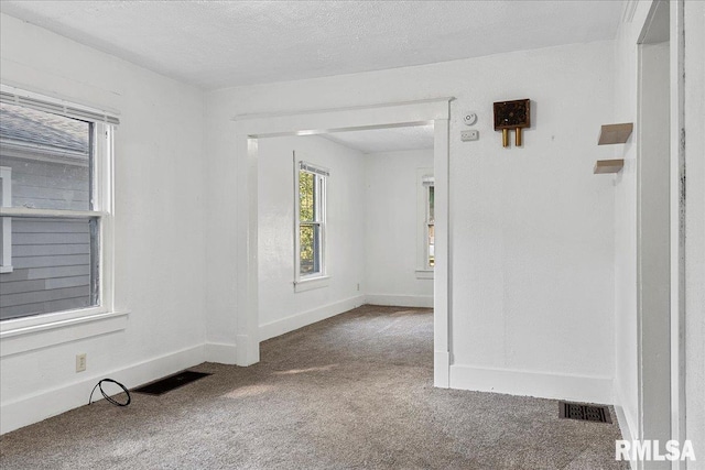 spare room featuring carpet floors and a textured ceiling