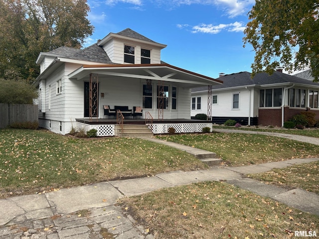 view of front of property featuring covered porch and a front lawn