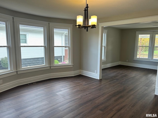 unfurnished dining area with a notable chandelier and dark hardwood / wood-style floors