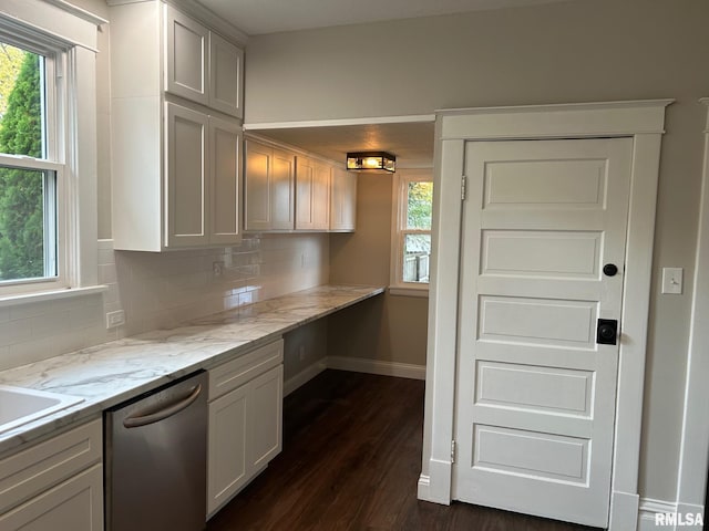 kitchen with dark hardwood / wood-style flooring, backsplash, white cabinetry, light stone countertops, and stainless steel dishwasher