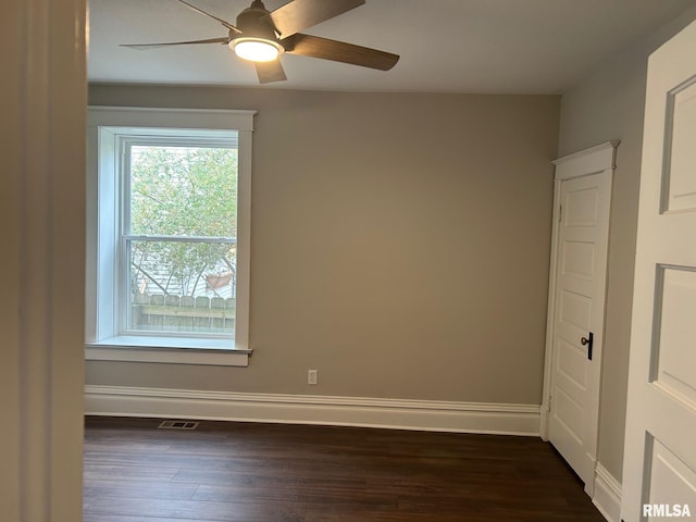 empty room with dark wood-type flooring and ceiling fan