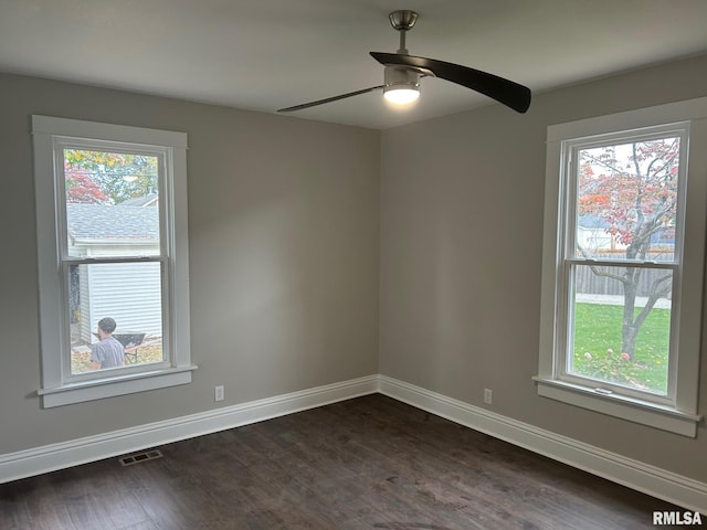 empty room with dark wood-type flooring, ceiling fan, and plenty of natural light