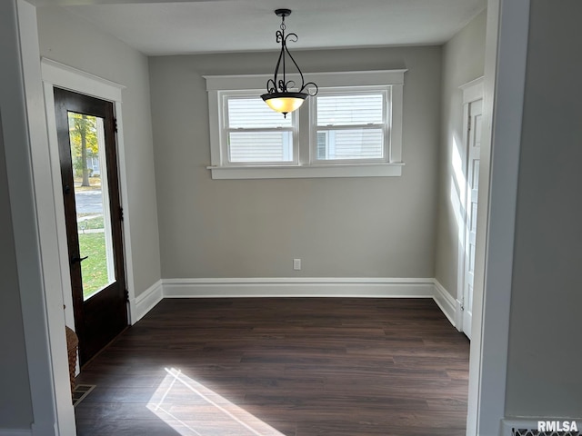 unfurnished dining area with dark wood-type flooring