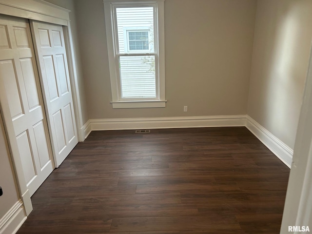 interior space with dark wood-type flooring and a closet