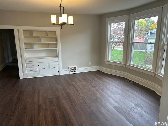 unfurnished dining area featuring dark hardwood / wood-style flooring and an inviting chandelier