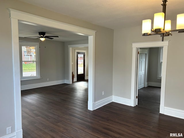 empty room featuring dark hardwood / wood-style floors and ceiling fan with notable chandelier