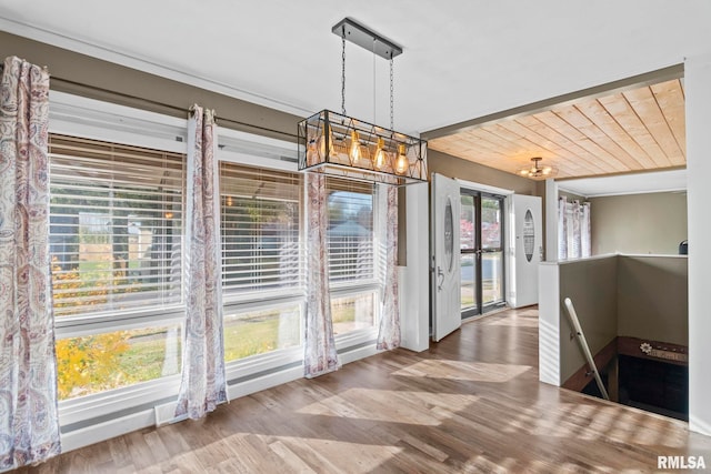 unfurnished dining area featuring wood ceiling and wood-type flooring