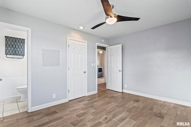 unfurnished bedroom with ensuite bathroom, light wood-type flooring, and ceiling fan