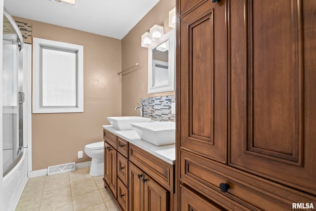 full bathroom with enclosed tub / shower combo, tasteful backsplash, toilet, vanity, and tile patterned flooring