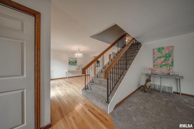 77 Country Pl Unit 77, Springfield, IL 62703 - stairway featuring a chandelier and hardwood / wood-style flooring