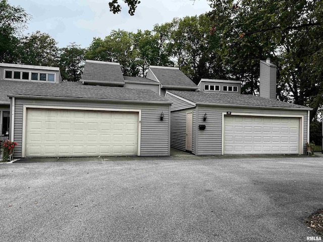 77 Country Pl Unit 77, Springfield, IL 62703 - view of front facade featuring an outdoor structure, a chimney, and a shingled roof