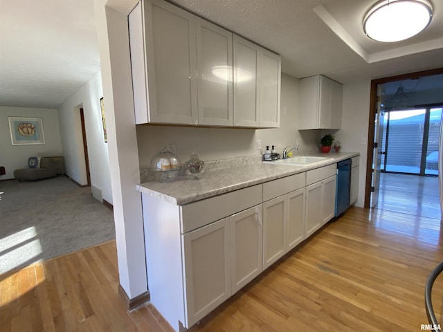 kitchen with white cabinetry, appliances with stainless steel finishes, light hardwood / wood-style flooring, and a textured ceiling