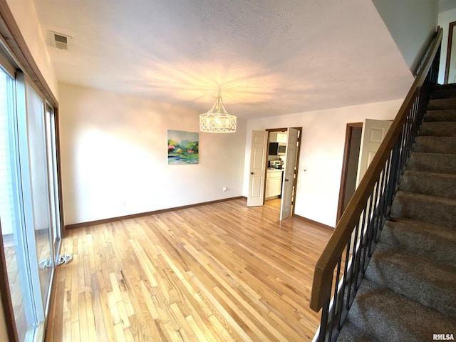 77 Country Pl Unit 77, Springfield, IL 62703 - empty room featuring stairs, light wood-style flooring, and a chandelier