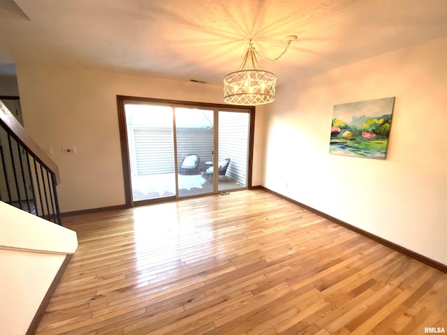 77 Country Pl Unit 77, Springfield, IL 62703 - spare room with stairway, light wood finished floors, and a chandelier