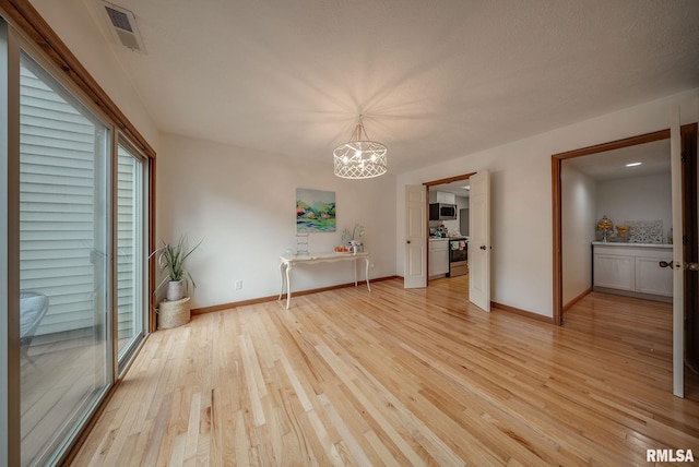 77 Country Pl Unit 77, Springfield, IL 62703 - unfurnished dining area featuring light wood finished floors and a chandelier