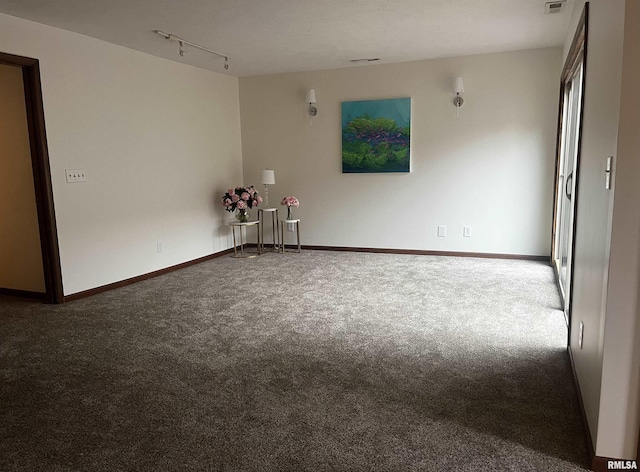 spare room featuring carpet floors and track lighting