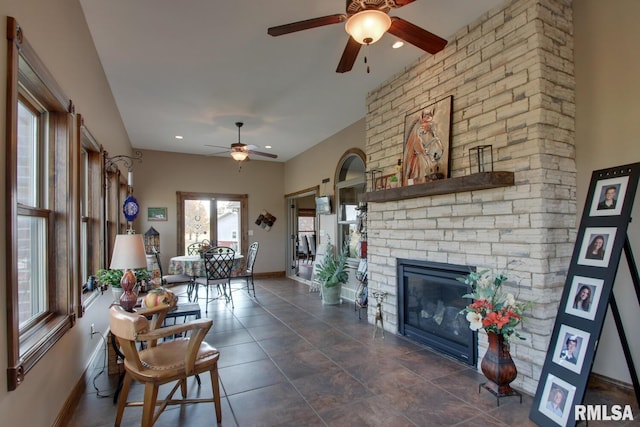 living room featuring a fireplace and ceiling fan