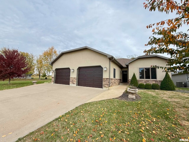 view of front of property with a front lawn, central AC, and a garage